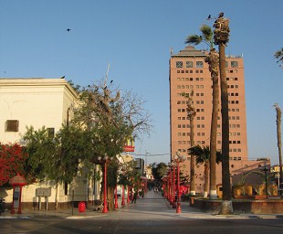 Cruce calle Prat con pasaje 21 de Mayo,
                        vista al edificio grande
                        "Empressarial"
                        ("Empresarial")