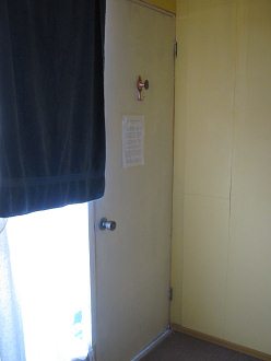 La puerta del cuarto con un gancho bello y
                        con el reglamento