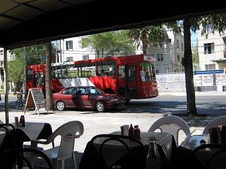 Un bus urbano rojo pasando el barrio
                        Patronato