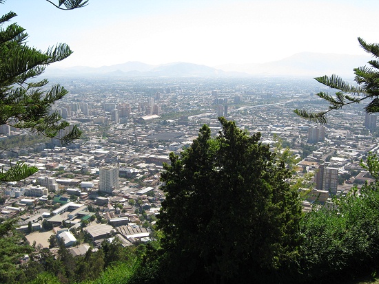 Aussicht von der Bergstation des
                            Metropolitano-Parks auf Santiago de Chile
                            mit Strauch