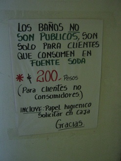 La puerta del bao con la indicacin como
                          usar el bao, con el precio de 200 pesos
                          chilenos para no consumidores del restaurante