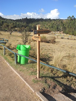 Cusco Sacsayhuam�n 16: Der Weg zur�ck nach Cusco, ein Wegweiser nach Q'enqo - der Wegweiser zum Toilettenh�uschen "Servicios higi�nicos"