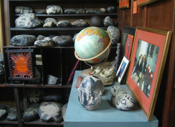 Das B�ro des Museums mit dem
                            Schreibtisch, mit einem Globus, Fotos und
                            einem Regal mit Steinen im Hintergrund