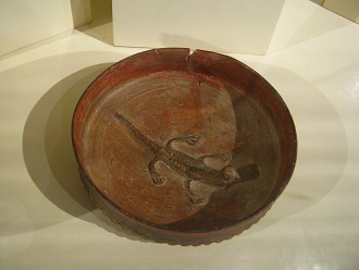 Ceramic plate of
                Chincha culture with modeled lizard in the middle