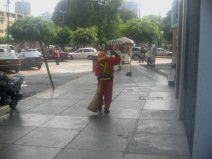 Miraflores, Jir�n Porta, limpieza callejera
                        por una mujer, al fondo se ve el parque Kennedy