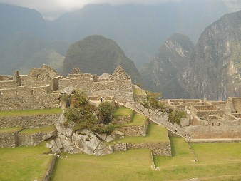 Machu Picchu, vista del cuarto de meditacin a
                    la plaza central con casitas trabajadores con la
                    montaa Putucusi 02