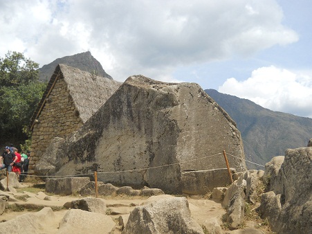 Machu Picchu, piedra sagrada, vista de atrás
                    con casita, son superficies gigantes cortadas