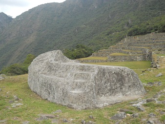 Machu Picchu, la piedra ceremonial, vista semi
                    lateral con una escalera al lado