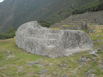 Machu
          Picchu, la piedra ceremonial, vista semi lateral con una
          escalera al lado