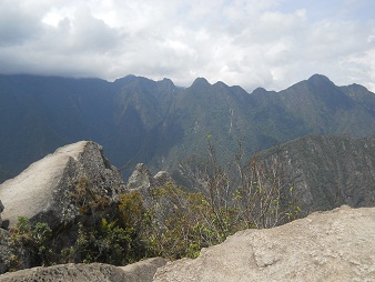 Machu Picchu, mirador Huaynapicchu, piedras
                    gigantes cortadas de la cantera en la punta con la
                    vista a montaas al fondo 03