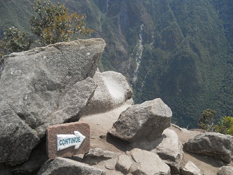 La cantera con piedras gigantes cortadas en la
                    punta del mirador Huaynapicchu, placa indicando el
                    camino de la bajada