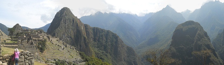 Sicht
                                auf Machu Picchu mit den Hausbergen
                                Huchuypicchu (klein), Huaynapicchu
                                (gross) und dem Putucusi-Berg und den
                                Bergen im Hintergrund, Panoramafoto